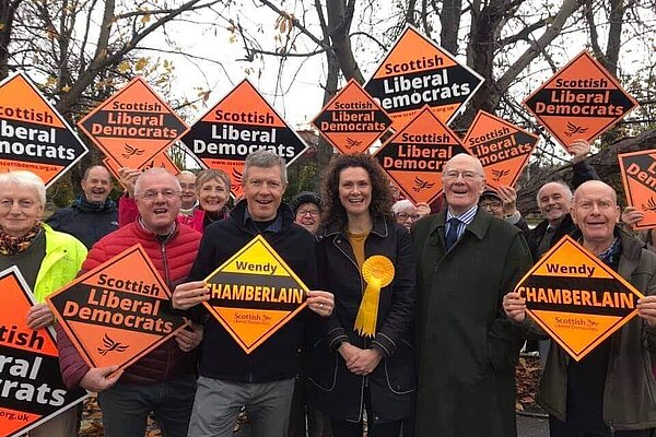 A crowd of Liberal Democrats holding signs