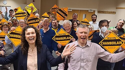 Willie Rennie MSP and Wendy Chamberlain MP in front of a crowd with Lib Dem signs